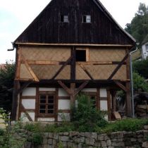 Restaurierter Giebel mit erhaltener Substanz von Fachwerk und Lehmgefachen